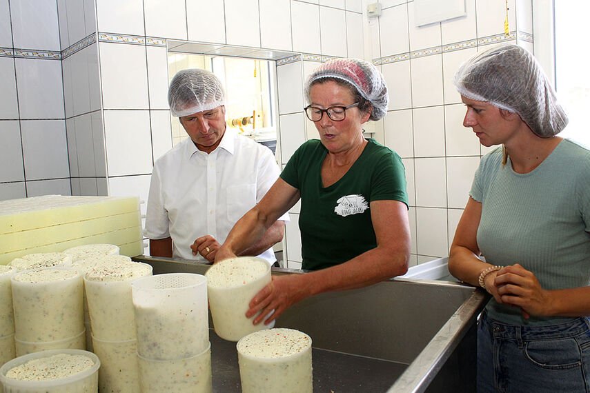 3 Personen bei der Käseherstellung.